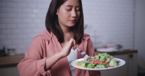 Young Woman Eats Healthy Salad at Home