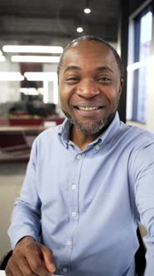 Man in Blue Shirt Talking to Camera Indoors