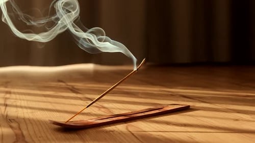 Incense Stick Burning with Smoke on Wooden Floor