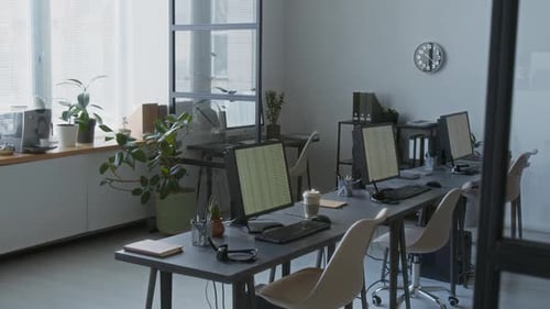 Modern Office Workspace Featuring Several Desks with Computer Monitors