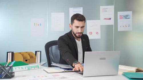 Man Working at Desk With Laptop in Office