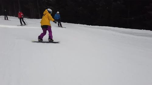 girl in yellow snowboarding in alps YL