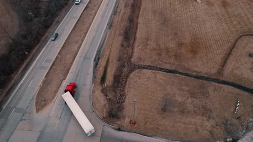 red semi tractor with white reefer-dryvan trailer doing right turn. Aerial USA 4k
