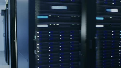 Black Handsome Employee Walks Through Server Corridor in a Data Center. His IT Colleague is Changin