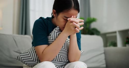 Pensive Woman Sitting on Couch with Pillow