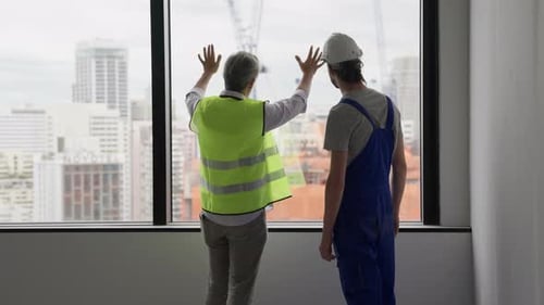 Engineer Contractor Working with Young Electrician on New Building