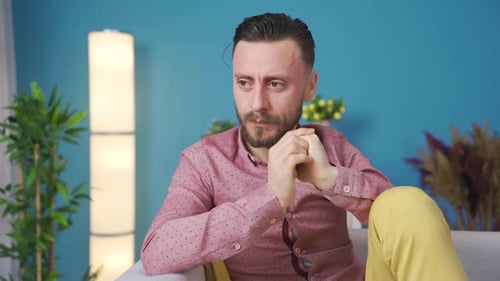 Man Sitting on Couch Deep in Thought