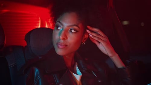 Glamorous Woman Rides in Car at Night