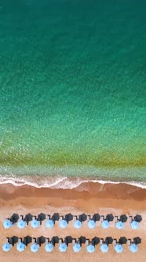 Topdown View of Sandy Beach with Sun Umbrellas and Turquoise Sea Water