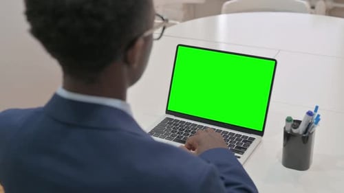 Overhead View of Young Businessman Using Laptop with Green Screen
