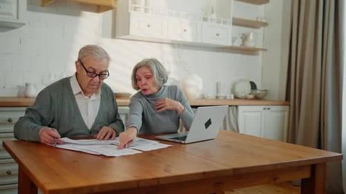 Aged Man and His Wife Controlling Utility Bills Checking Bank Papers at Home Greyhaired Woman and