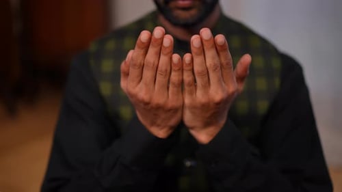 Closeup Hands of Young Muslim Man Praying Touching Face at Home on Ramadan Front View Unrecognizable