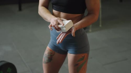 Woman preparing for weightlifting workout in gym, showing focus and determination before lifting