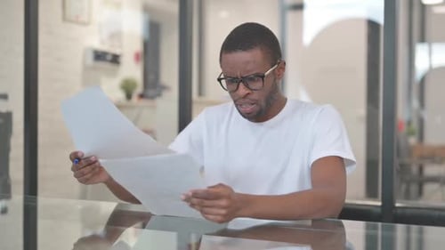 Young Adult Reviewing Documents Looking Stressed
