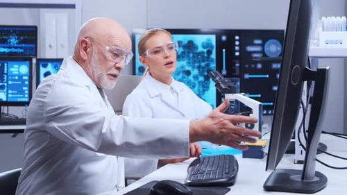 Scientists Collaborating Using Computer and Microscope in Lab