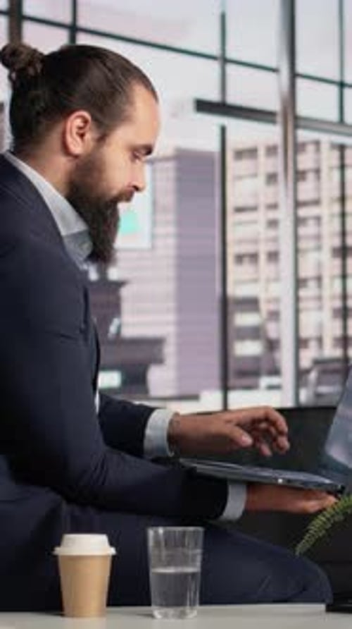 Vertical Video Businessman on Laptop Reviewing KPIs and Planning Executive Strategy