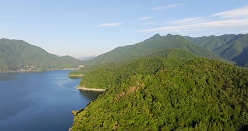 Aerial following the coastline of lake Kawaguchi, sunny, summer day in Japan