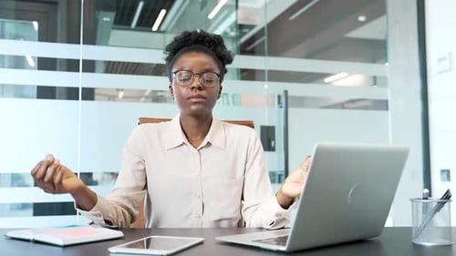 Woman Meditating at Desk in Modern Office