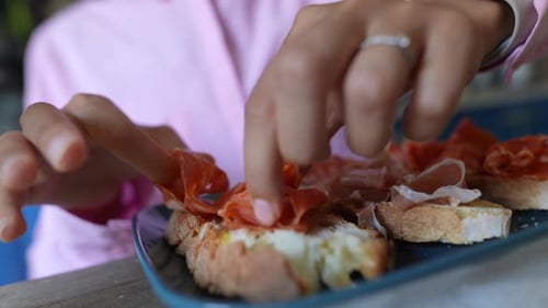 Une personne place soigneusement un assortiment de viandes et de fromages sur un plateau de charcuterie