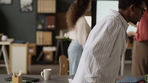 Man Working at Desk while Woman Creating Presentation