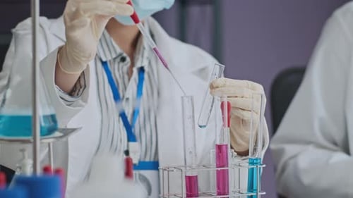 Medical Scientist Analyzing Colorful Fluids in Laboratory