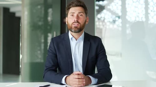 Webcam view. Businessman in a formal suit talking on a video call looking at camera sitting