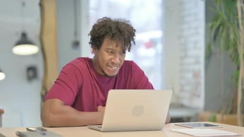 African Man Reacting to Loss While Working in Office