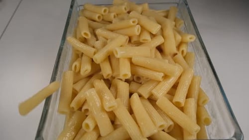 Pasta Falling into Glass Container