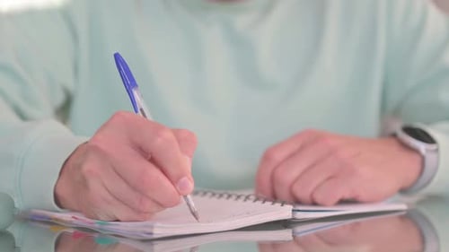 Close up of Man Writing on Notebook