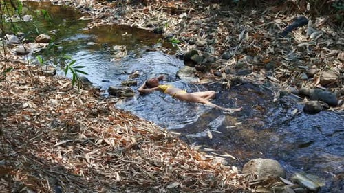 Woman Relaxes in Tropical Stream