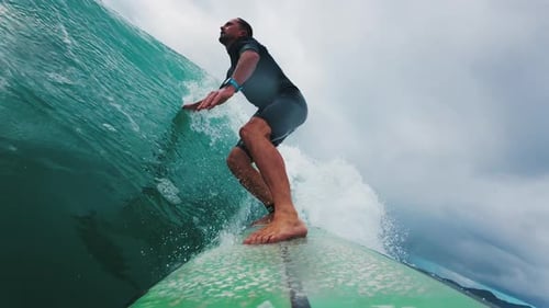 Surfer in wetsuit rides the wave in Atlantic Ocean. Surfboard camera view of the surf rider