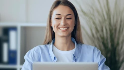 Jeune femme travaillant assidûment sur un ordinateur portable dans un espace de bureau lumineux pendant la journée