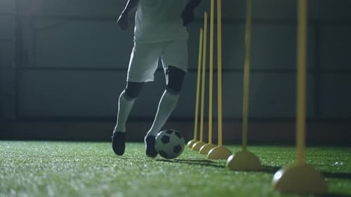 African American Footballer Training in Soccer Club Running Between Sticks Practicing Dribbling