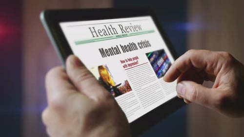 Mental health crisis newspaper on mobile tablet screen