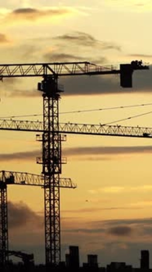 Sunset Over Progress Construction Cranes Silhouetted Against the Evening Sky