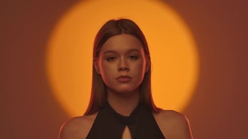 Elegantes Portrait einer Frau mit Dramatisch orangefarbener Hintergrundbeleuchtung