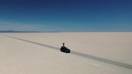Vista aérea del lago salado de Uyuni con coche y personas, Uyuni, Bolivia.