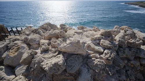 Close up of rugged limestone rocks along the coastline with the Mediterranean Sea in the background