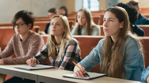 Diverse students attentively listen during a university lecture