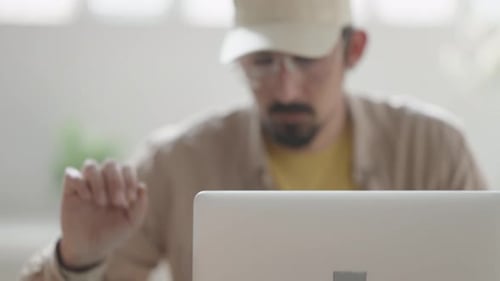 Man Works at Desk with Laptop and Tablet
