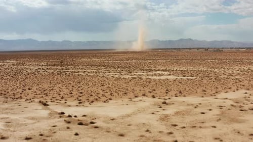 A desert sandstorm kicks up a dust devil in the Mojave Desert landscape - aerial view of the twister