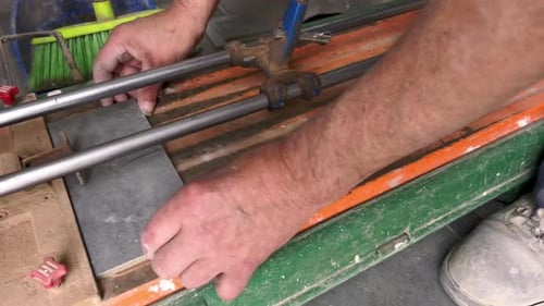 Craftsman Cuts Tile on a Tile Cutter Machine