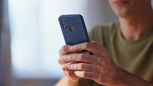 Adult using smartphone indoors in close up