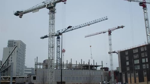 Urban commercial construction: Tower cranes operate in the grey sky