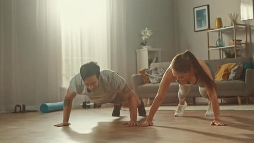 Couple doing pushups and high five at home