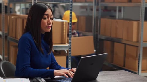 Woman Working in Warehouse Accepts Box