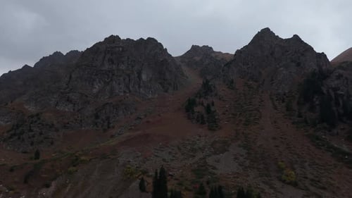 Majestic Mountain Landscape Showcasing Rocky Peaks and Autumn Foliage in a Dynamic Scene