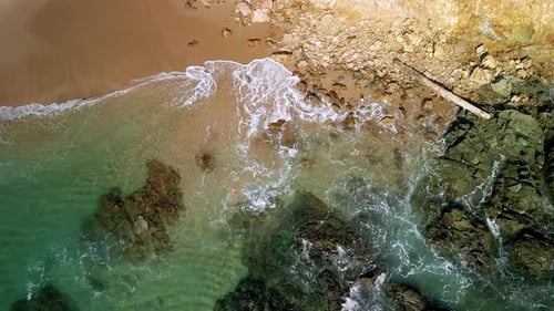 Les vagues déferlent sur le rivage d'une plage rocheuse