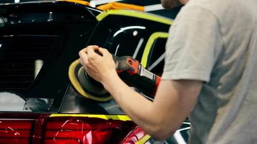 Car Detailing at a Service Station Black Car is Covered with Yellow Tape the Process of Polishing a