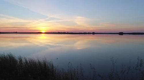 Aerial Over the Lake at Sunset Soft Sunset Skies Reflections on Calm Water Surface Stunning Summer